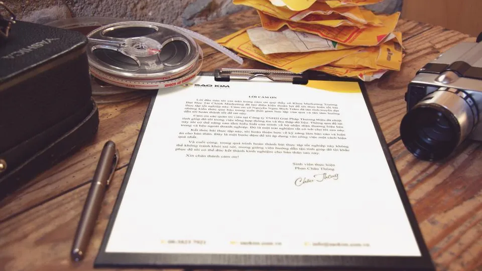 Prancheta com documento assinado e caneta sobre uma mesa de madeira